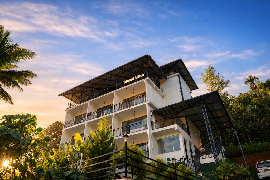 a white building with a black roof at Mount Minar Munnar in Anachal