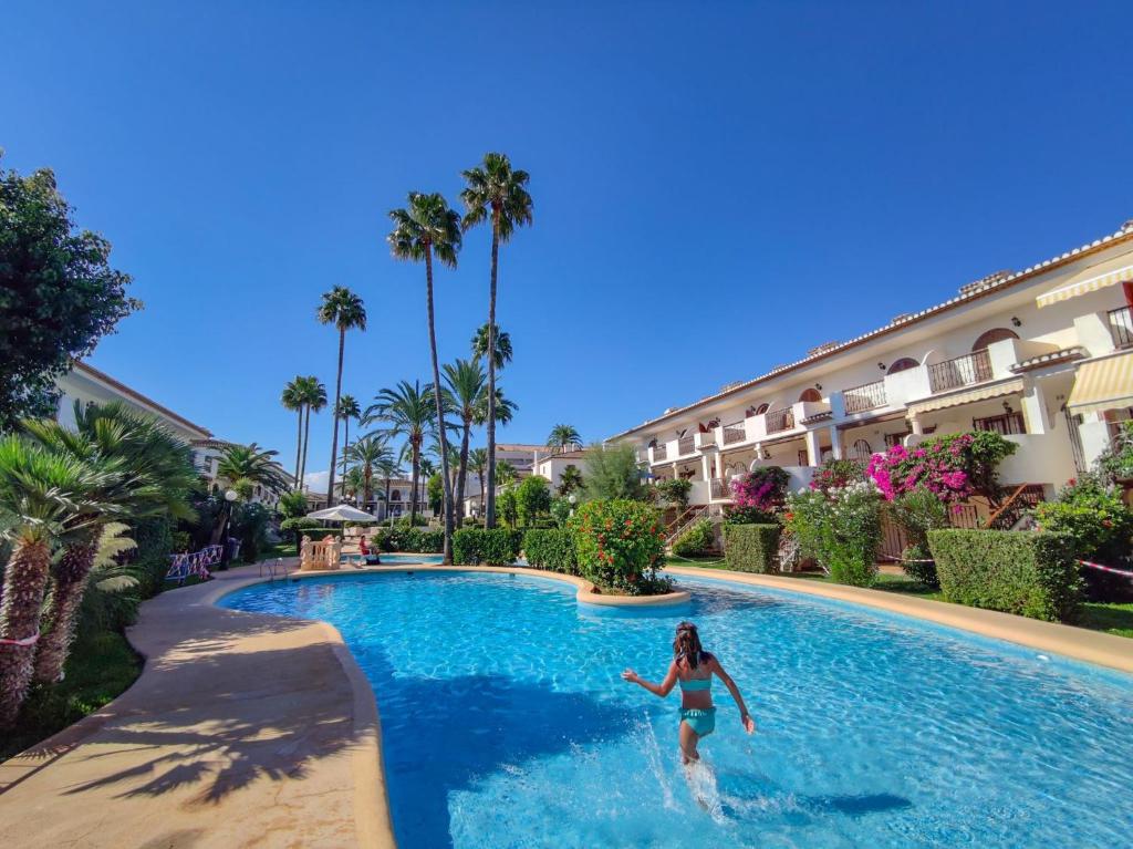 a woman in a swimming pool at a resort at Beachfront in Denia Alicante in Denia