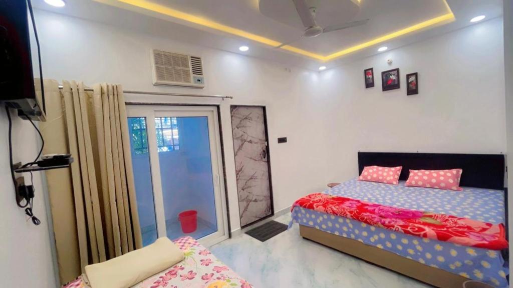 a bedroom with a bed and a sliding glass door at SUNRISE Near Lucknow Airport in Lucknow