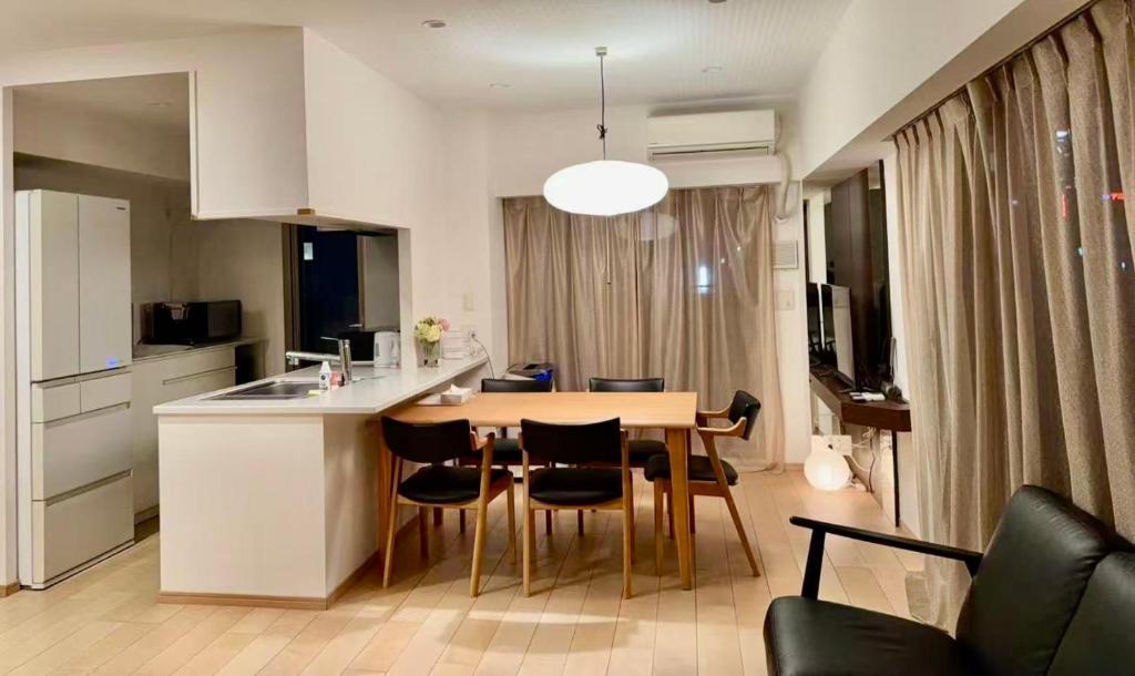 a kitchen and living room with a table and chairs at 青葉邸 AOZORA 1002 Near Dotonbori 3LDK 2 Bath 2 WC Premium Tower Residence in Osaka