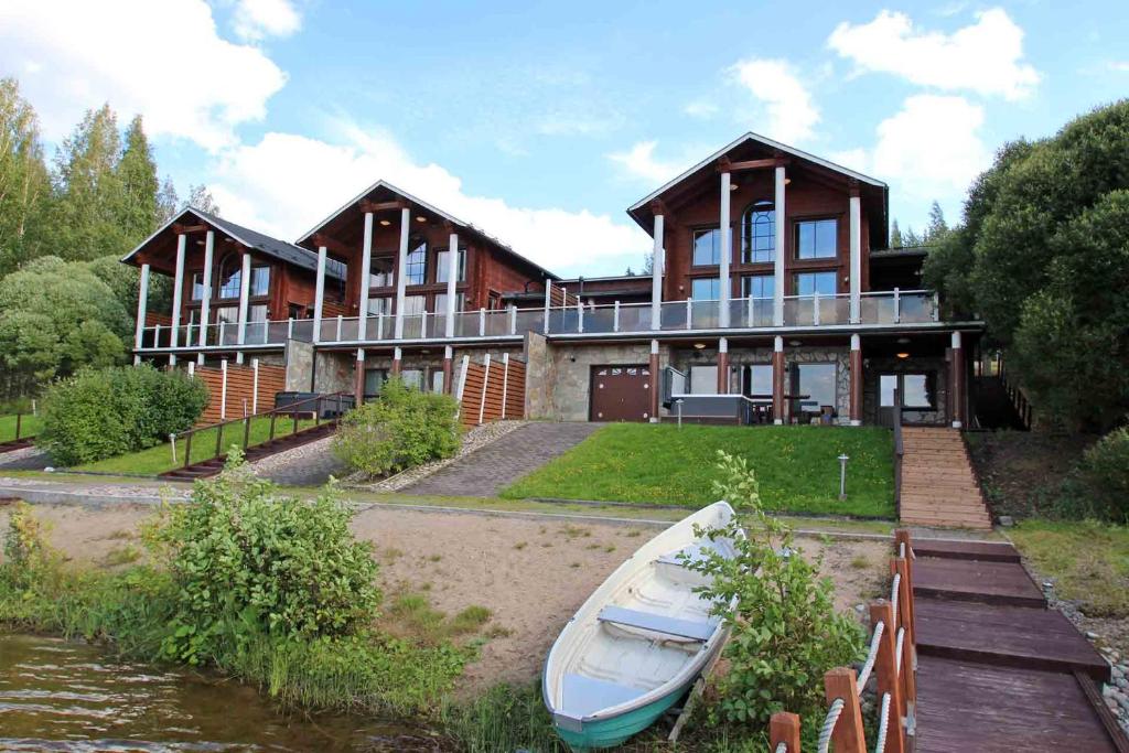 a large house with a boat in front of it at Päijänteen Helmi 1 in Jämsä