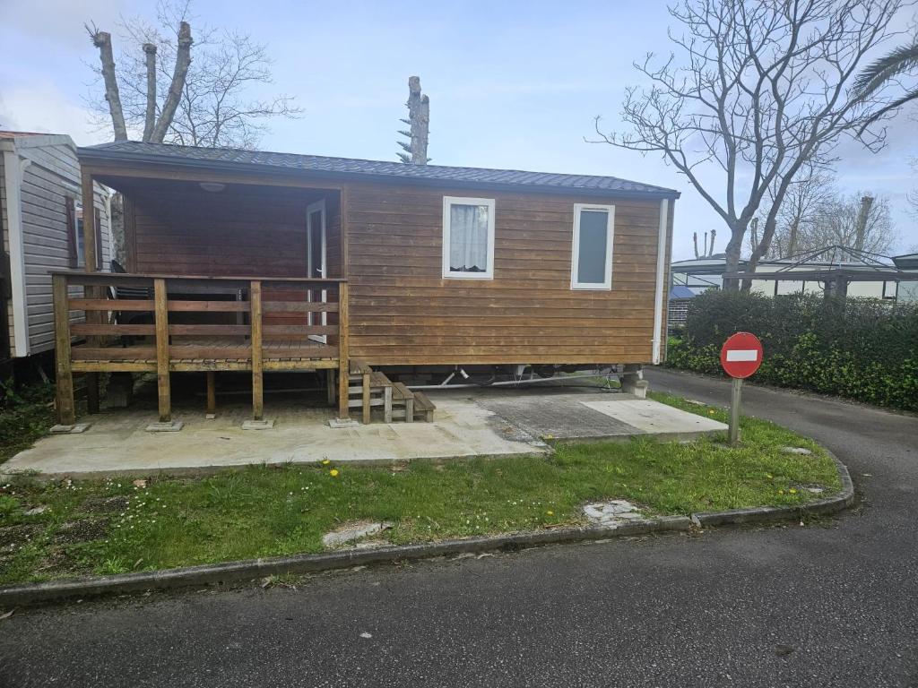 a tiny house with a porch and a stop sign at Camping Arenas in Bareyo