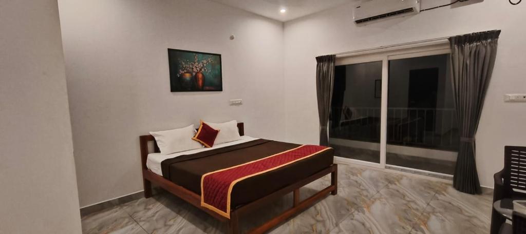 a small bedroom with a bed and a window at La Nature Retreat in Puducherry Airpoert