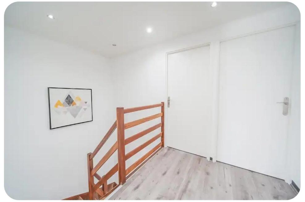 a room with a wooden staircase and a white wall at Chez moi in Mont-Saint-Martin