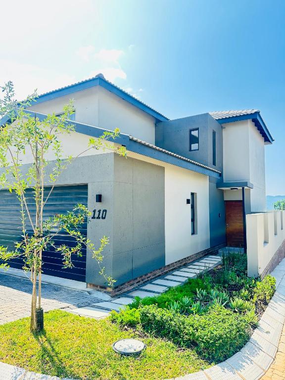 a white house with a garage at Elusive Haven in Nelspruit