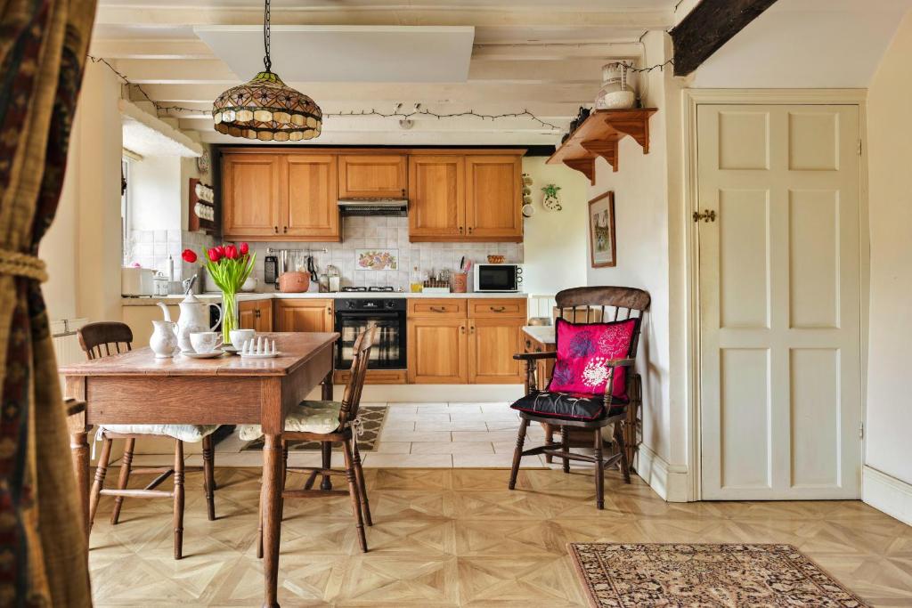 a kitchen with wooden cabinets and a table and chairs at Finest Retreats - Vine Barn in Bellerby