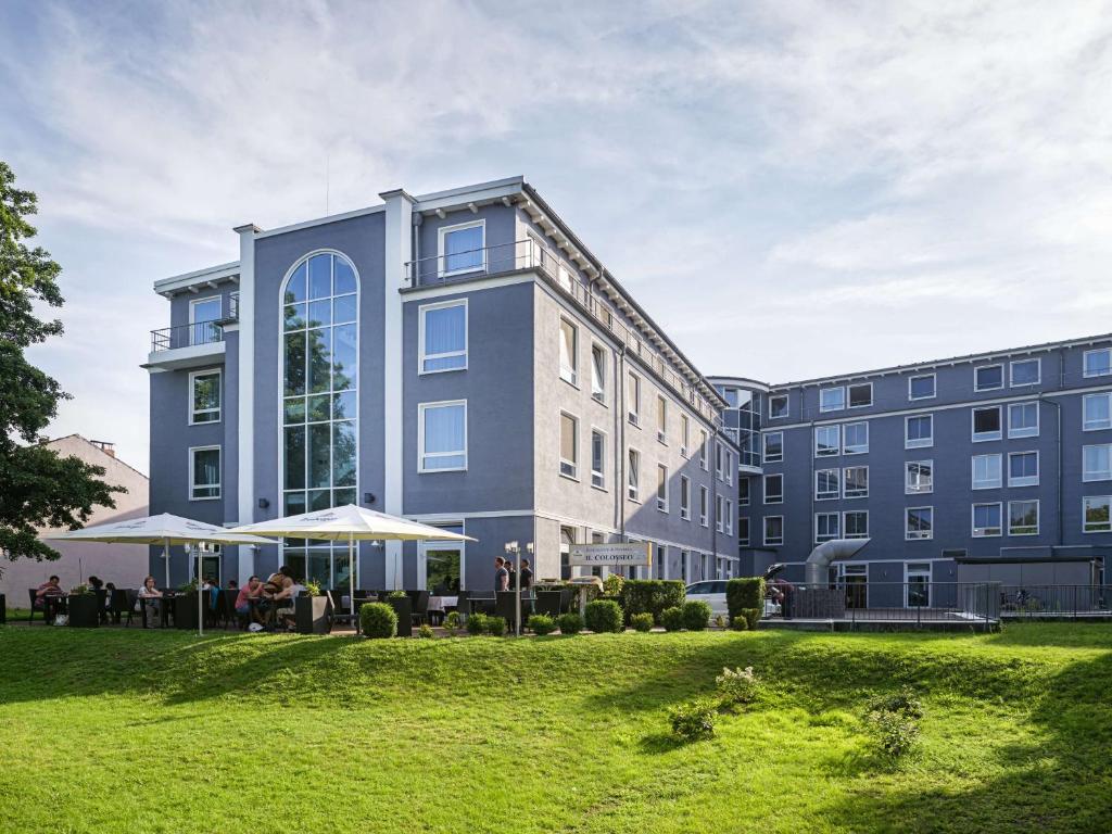 a building with a green lawn in front of it at Hotel am Schloß Köpenick by Golden Tulip in Berlin