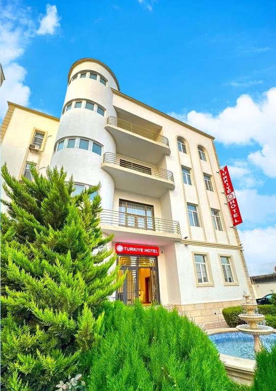 a building with a tree in front of it at Turkiye Hotel - Free Massage - Free Swimming Pool in Baku
