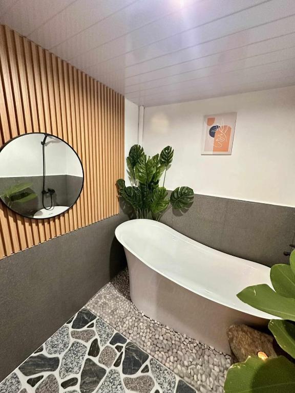 a bathroom with a tub and a potted plant at Maria Staycation House in Davao City