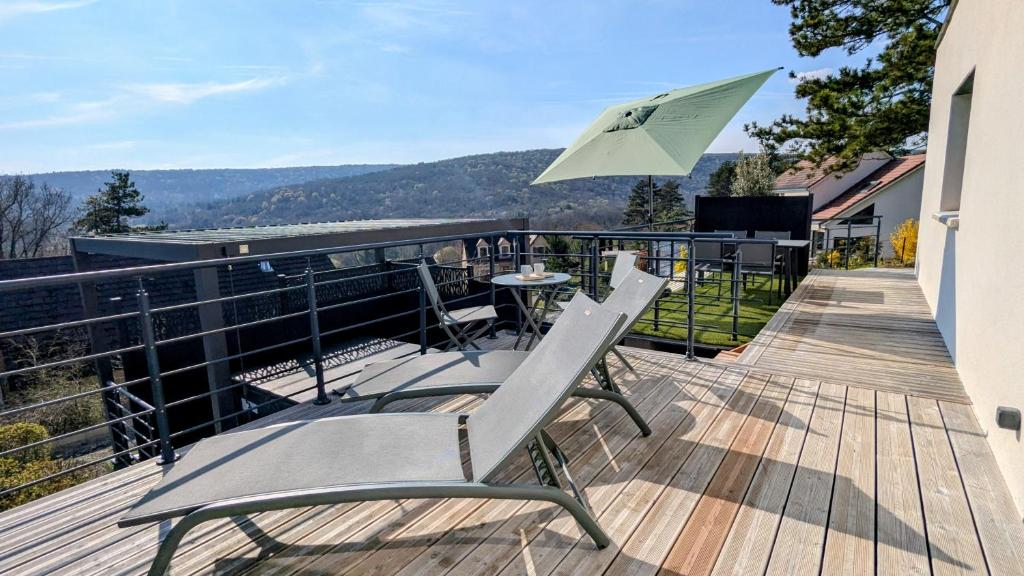 a patio with two chairs and a table and an umbrella at Savigny Vineyard View & SPA in Savigny-lès-Beaune