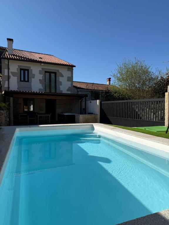 a swimming pool in front of a house at A Casa da aldea de Iria in Padrón