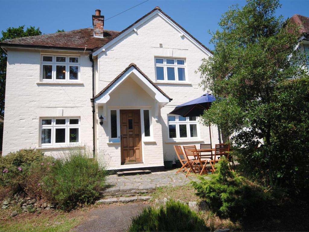 a white house with tables and chairs in front of it at 4 Bed in Swanage oc-dc046 in Studland