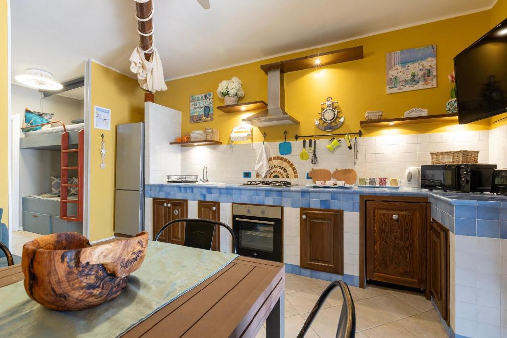 a large kitchen with yellow walls and blue counter tops at Casa Fiamma in Stintino