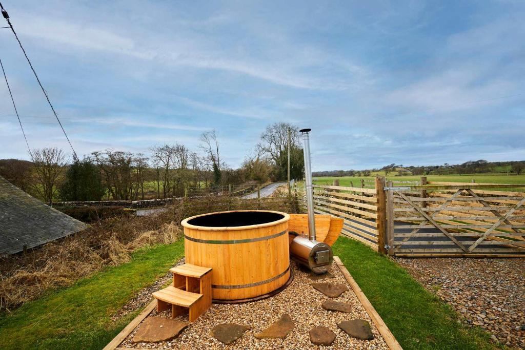 a barrel sitting on the ground next to a fence at Host & Stay - Kingbridge Forge in Lanercost