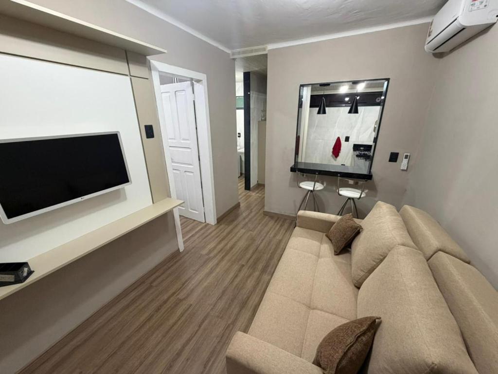 a living room with a couch and a flat screen tv at Casa aconchegante em Olaria in Nova Friburgo