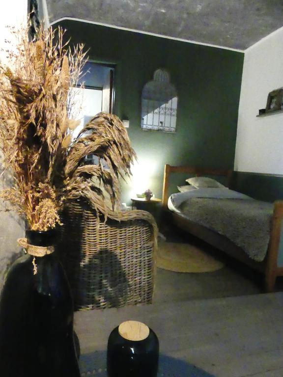 a bedroom with a bed and a vase with plants at Suite romance in Froid-Chapelle