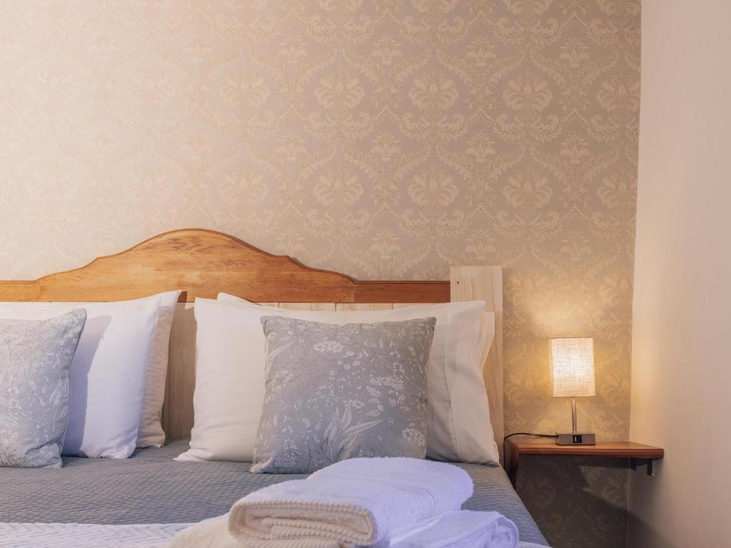 a bedroom with a bed with white pillows at La casetta di Mercatello in Bagnoregio