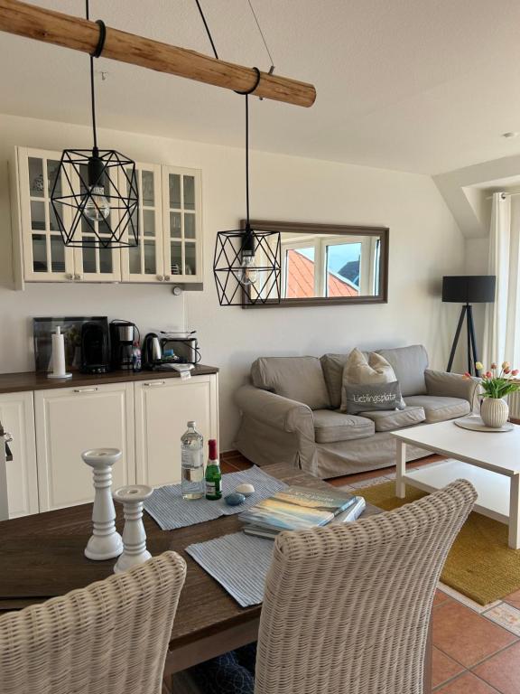 a living room with a table and a couch at Fewo Schröder - BUDE 63a - mit Strandkorb am Meer - inklusive Bettwäsche und Handtücher in Westerdeichstrich