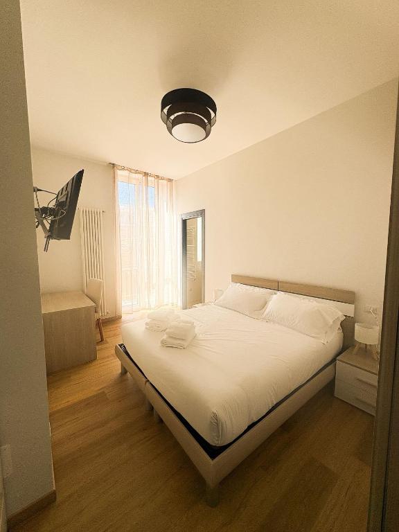 a bedroom with a white bed with a large window at Le Tre Lune Rooms in Matera