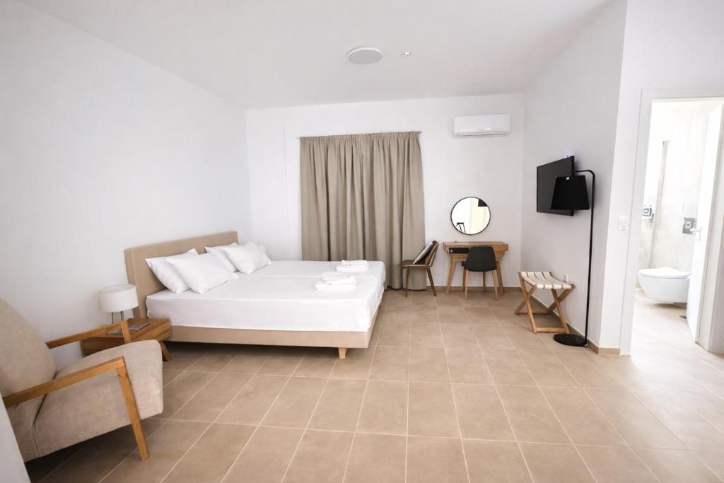 a bedroom with a white bed and a bathroom at CONSTA Luxury Apartments in Paralio Astros