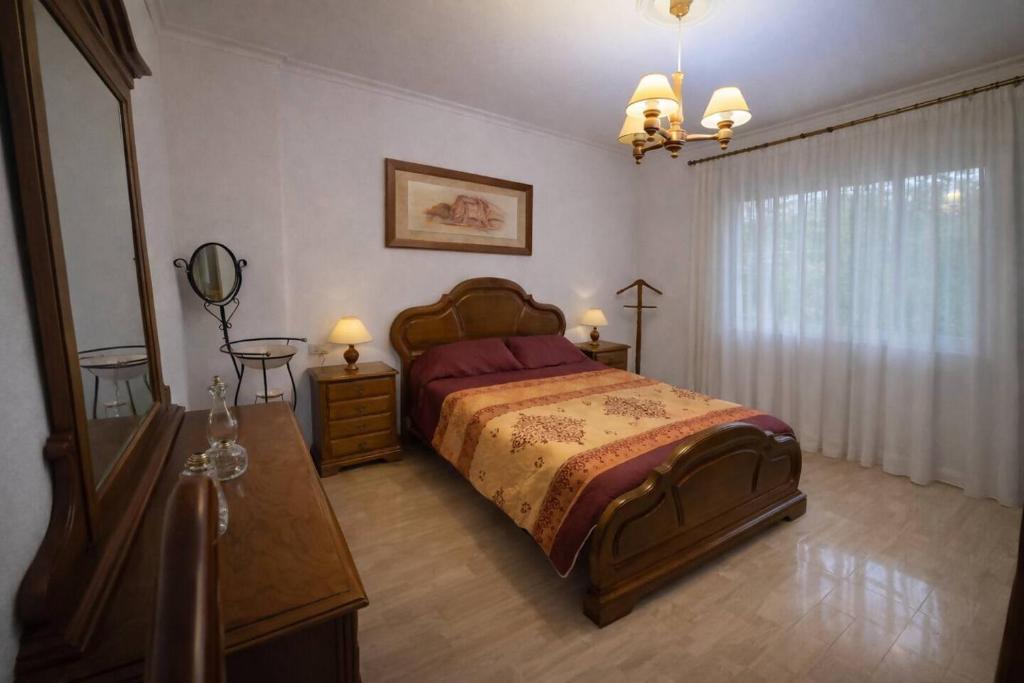 a bedroom with a bed and a dresser and a mirror at Isa Rooms Sarria in Sarria