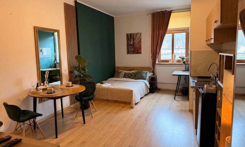a bedroom with a bed and a table and a desk at Pod Aniołami in Wałbrzych