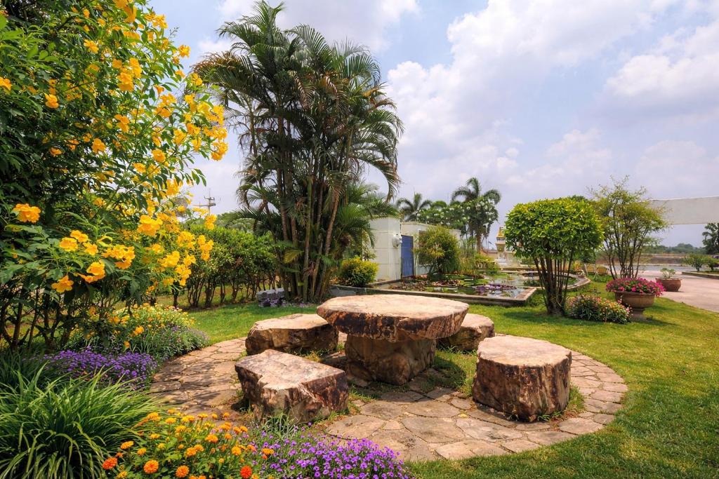a park with a bench and trees and flowers at The Room Suphanburi in Ban Nong Chaeng