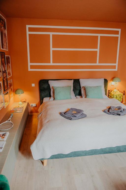 a bedroom with two beds and a desk with two lamps at sleepArt match point in Celle