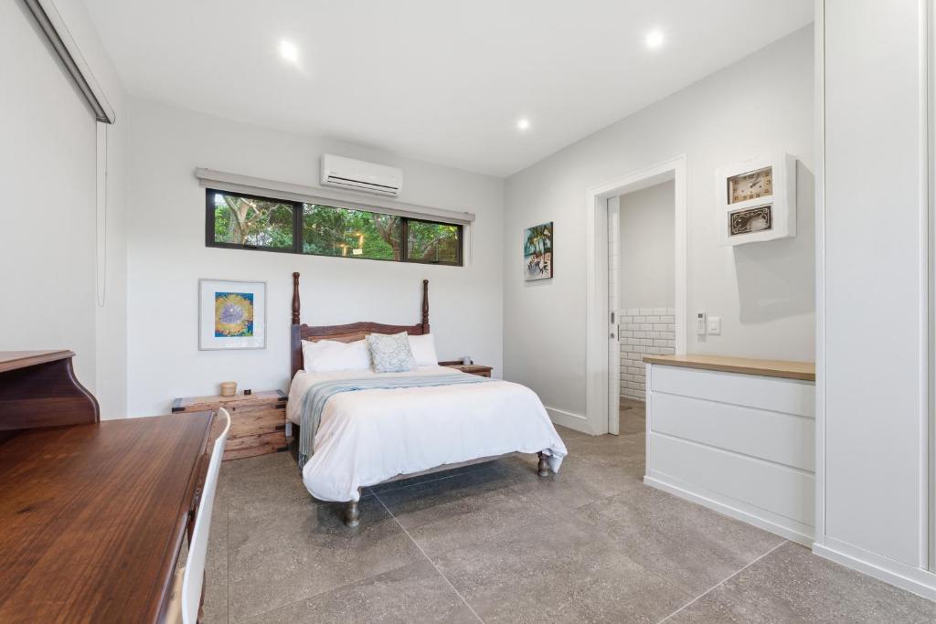 a white bedroom with a bed and a window at Octopus Room in Ballito