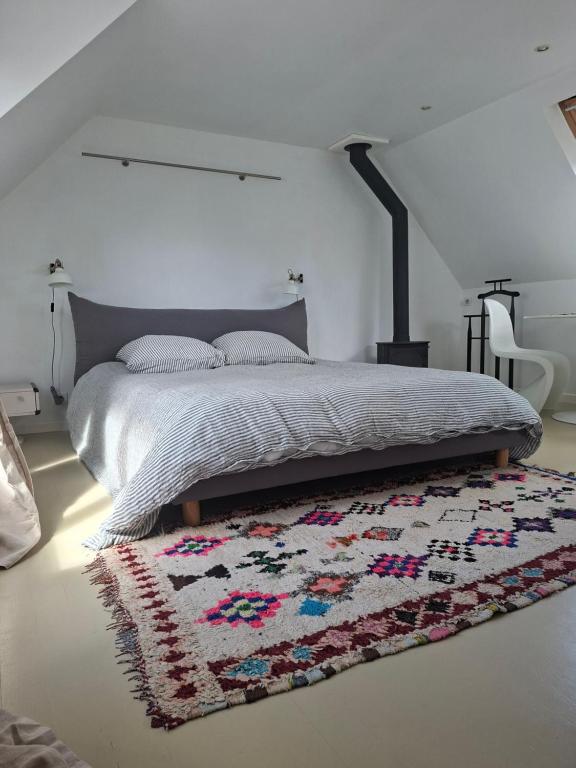 a bedroom with a bed with a rug on the floor at Studio Les 4 Vents in Tréffiagat