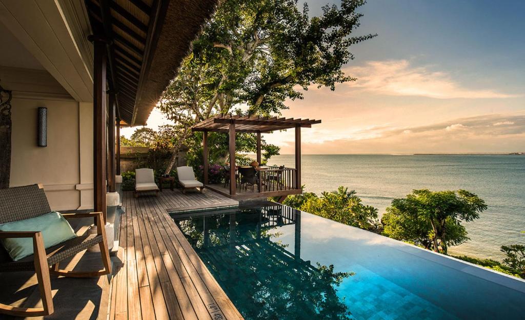 a house with a swimming pool with a view of the ocean at Four Seasons Resort Bali at Jimbaran Bay in Jimbaran