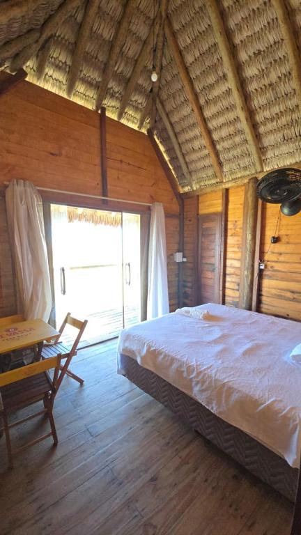 a bedroom with a bed and a large window at Chalé mirante in Tutóia