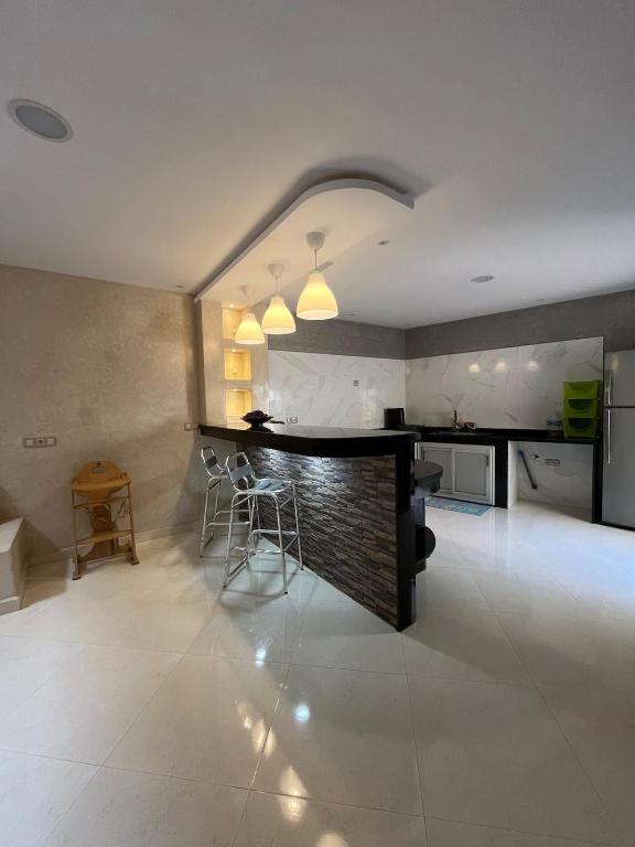 a kitchen with a bar and chairs in a room at House with beautiful partial sea view in Mirleft
