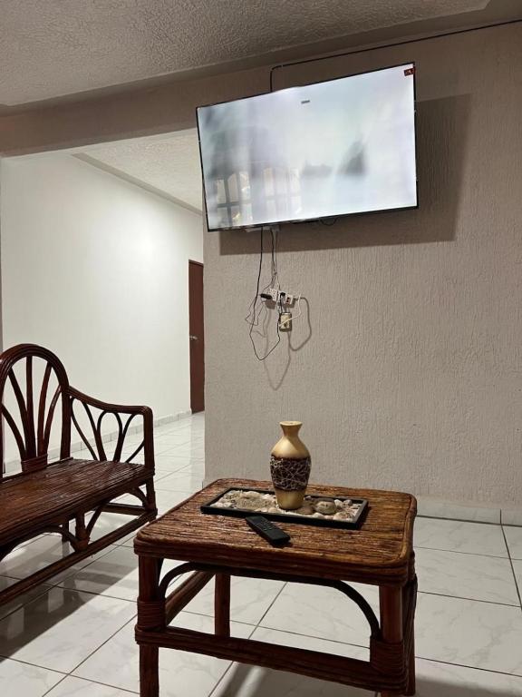 a living room with a table and a tv on the wall at Casa Ale in Brisas de Zicatela