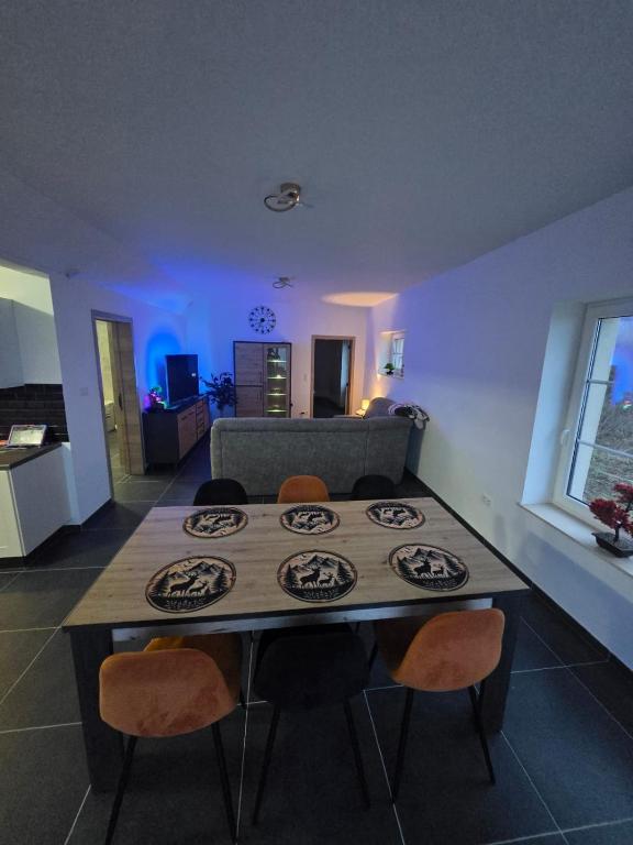 a dining table and chairs in a living room at Le Marronnier in Bastogne