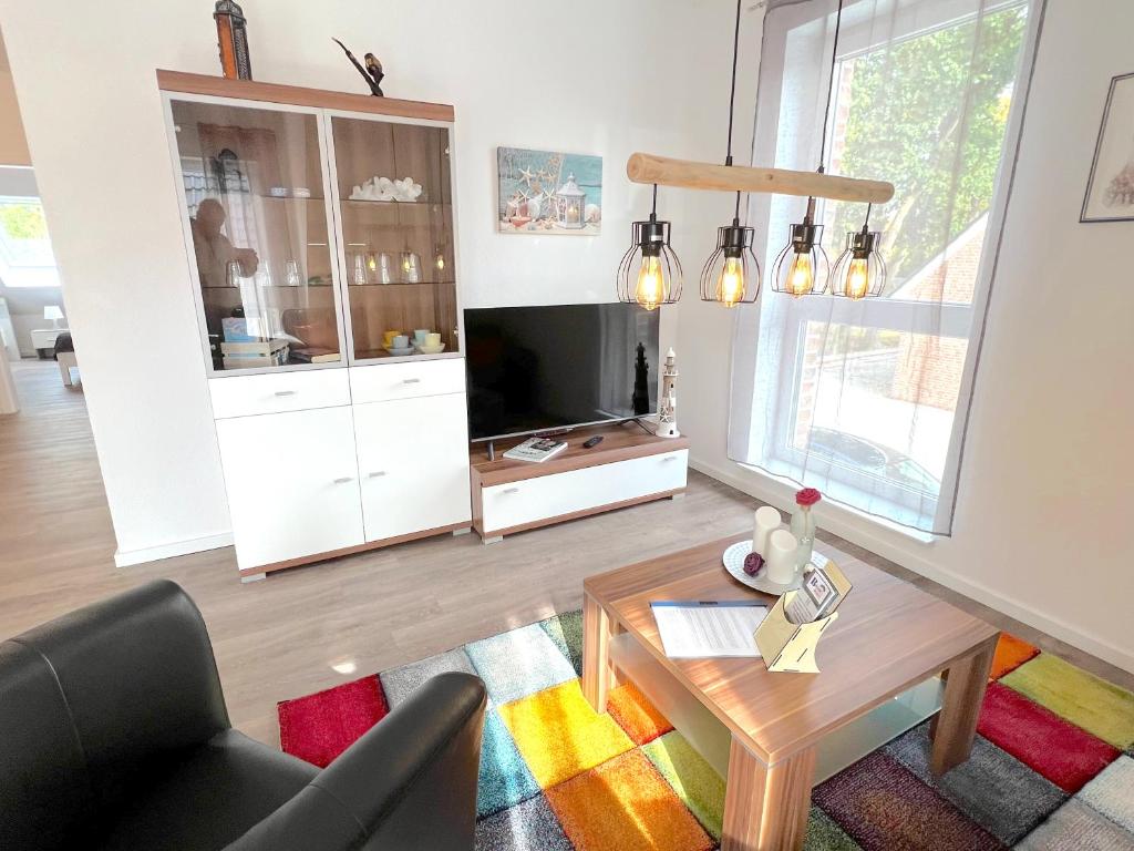 a living room with a tv and a table at "Atlantis" Papenburg Dachterrasse Einbauküche Neubau 74 qm Free Wifi 2 Schlafzimmer bis 4 Personen in Papenburg
