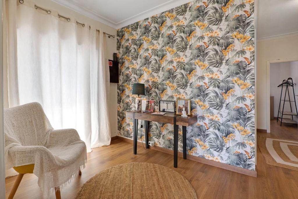 a room with a desk and a wall with a wallpaper at Vitóriahouse - Your Little Corner in Vila Nova de Gaia