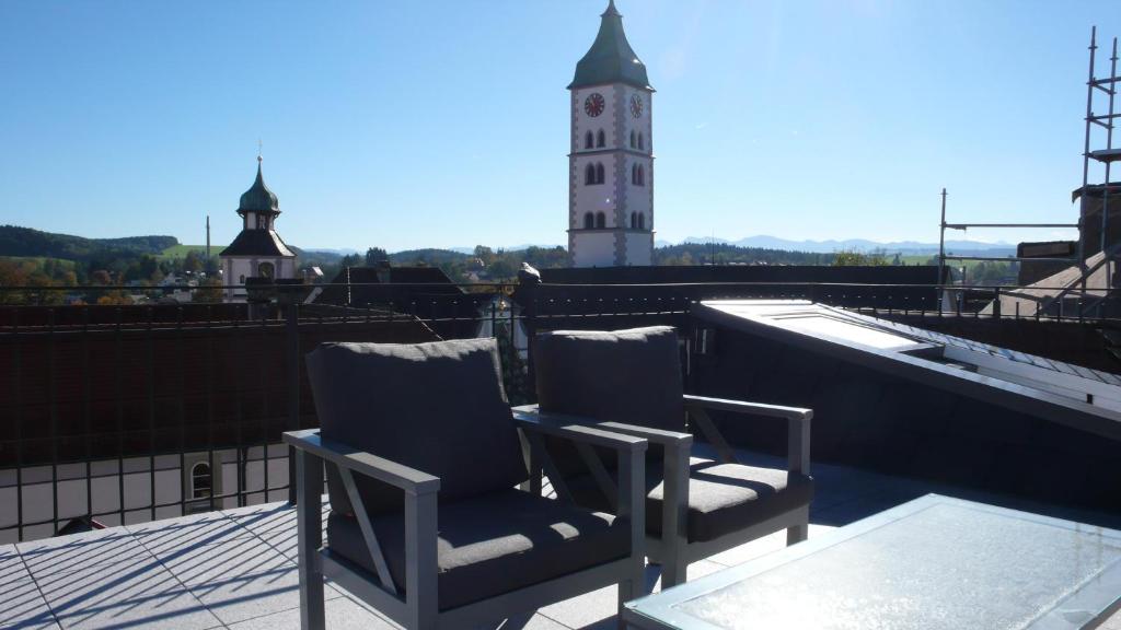 two chairs sitting on a roof with a clock tower at Design trifft Denkmal in Wangen im Allgäu