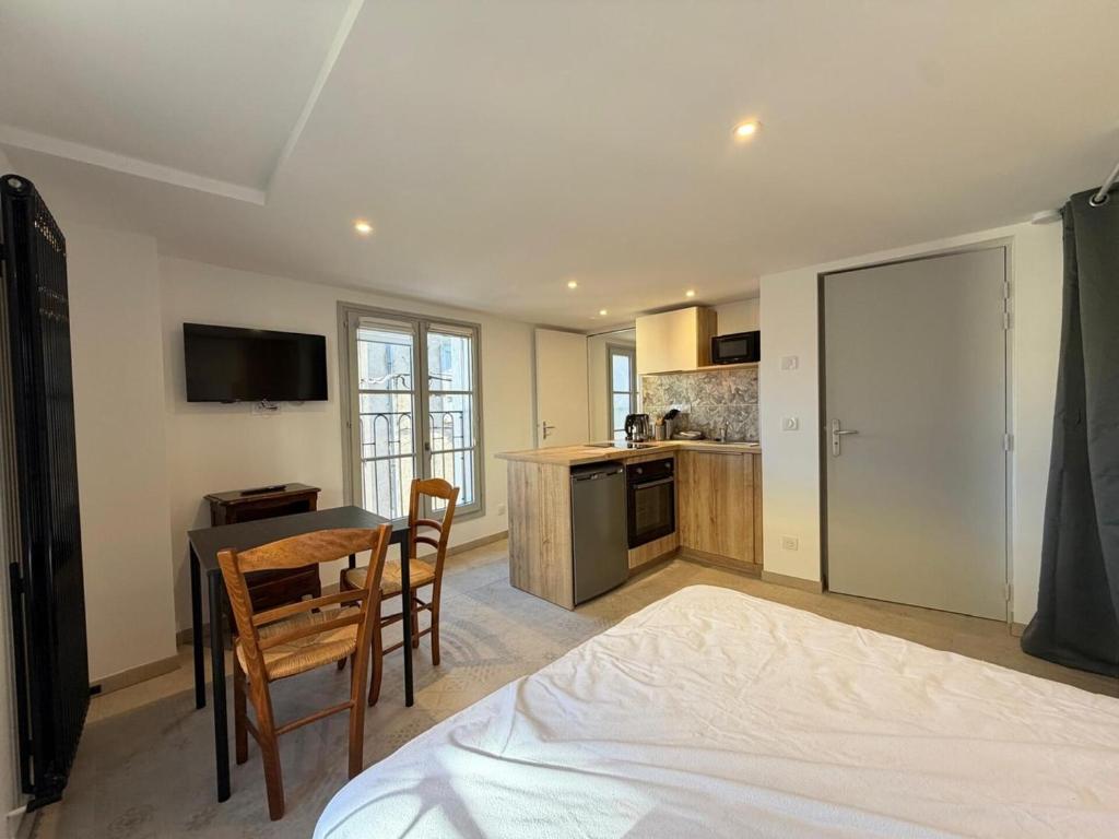 a bedroom with a table and chairs and a kitchen at Les suites Villeneuve - 3 in Le Puy-en-Velay