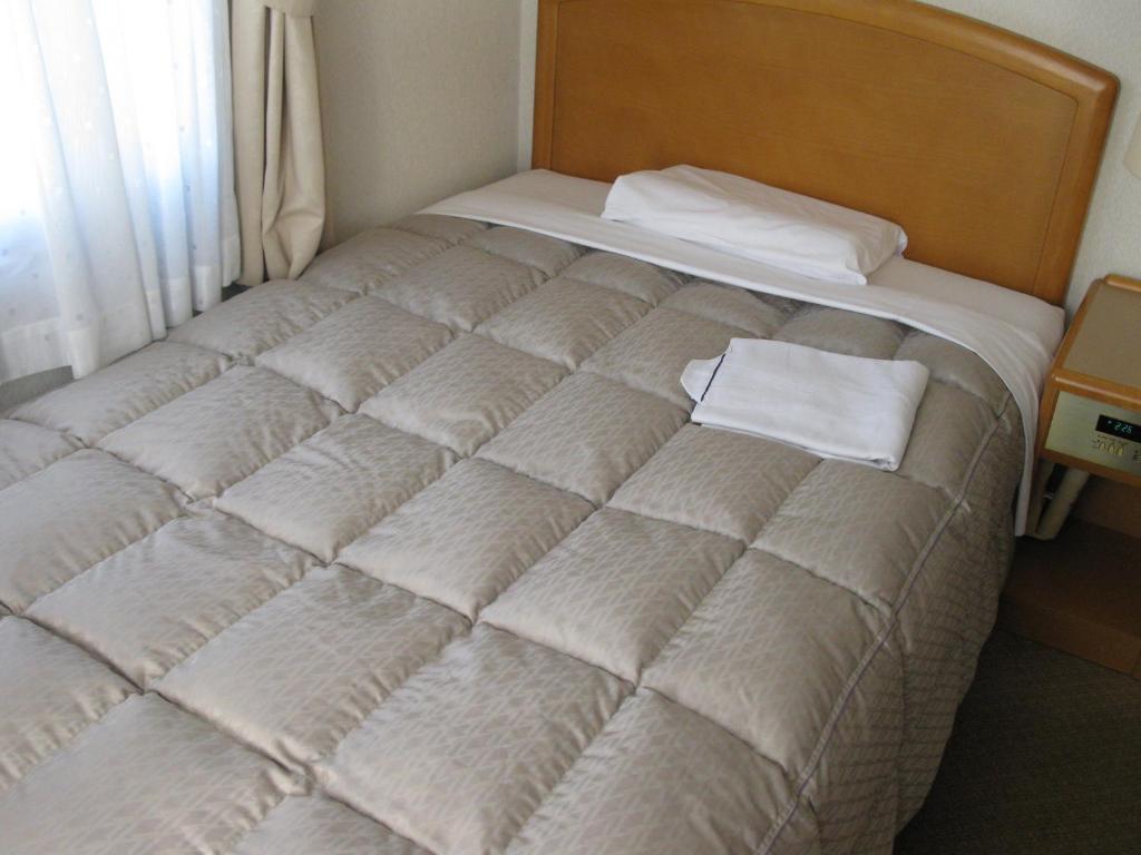 Postel nebo postele na pokoji v ubytování Mito Riverside Hotel