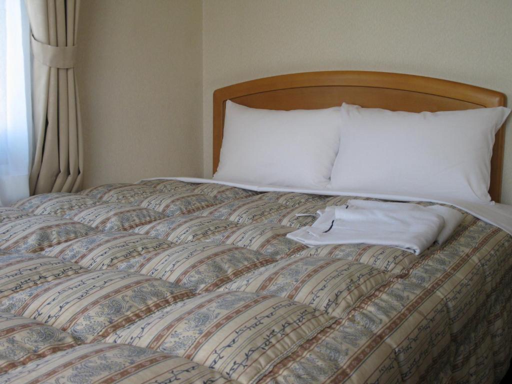 Postel nebo postele na pokoji v ubytování Mito Riverside Hotel