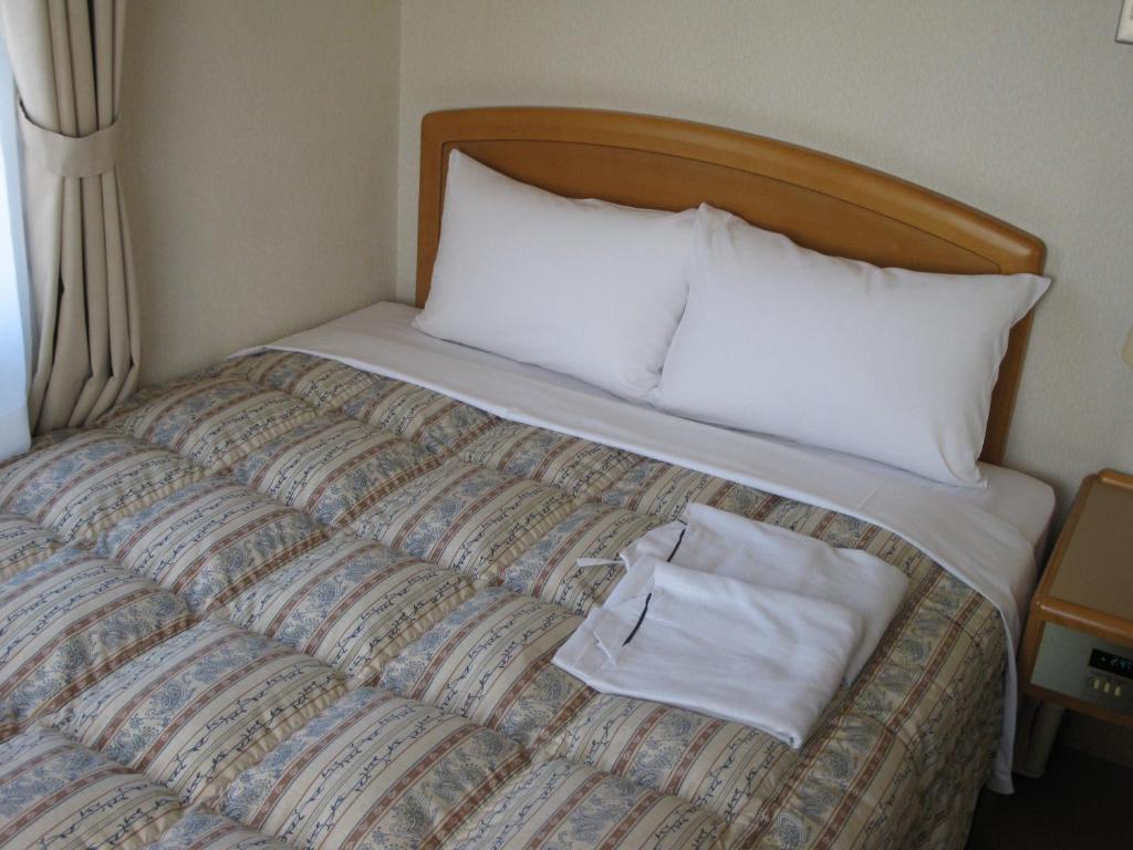 Postel nebo postele na pokoji v ubytování Mito Riverside Hotel