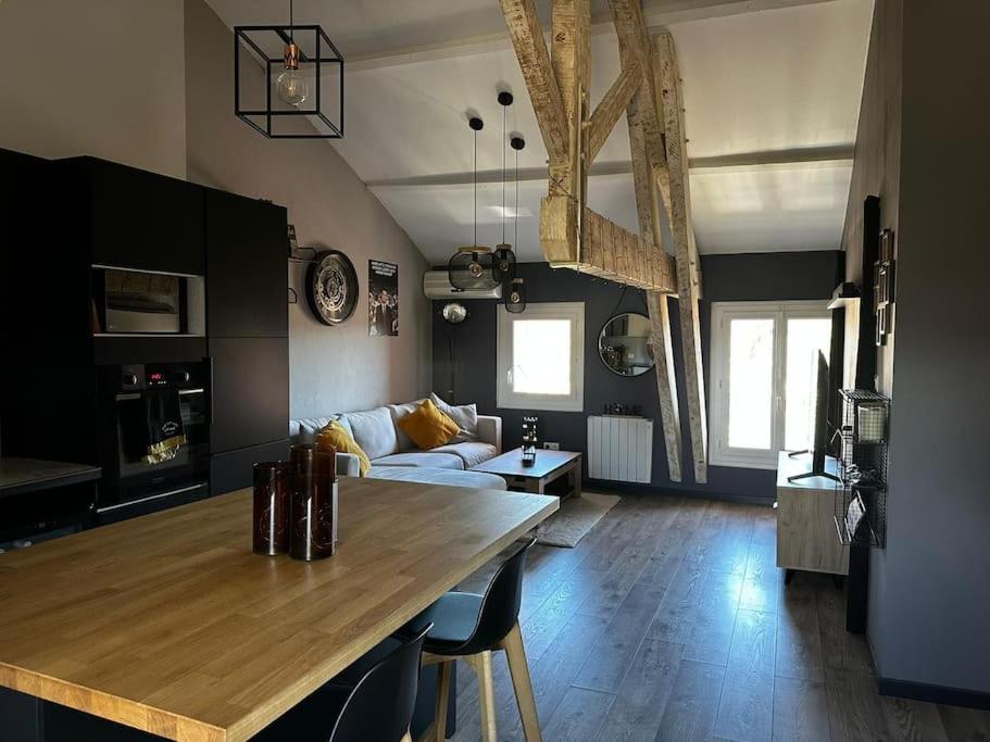 a kitchen and living room with a table and a couch at Charmant loft industriel de 40m2 in Aubignan