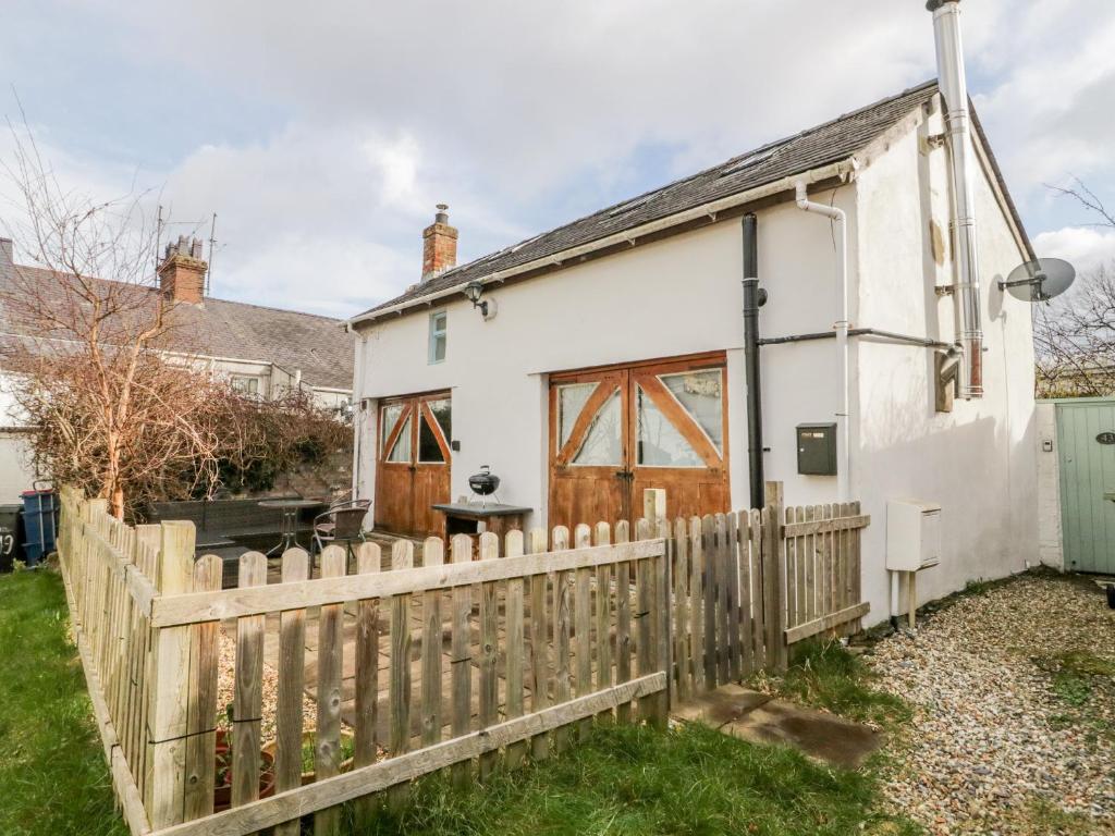 a white cottage with a wooden fence at Studio Bach in Beaumaris