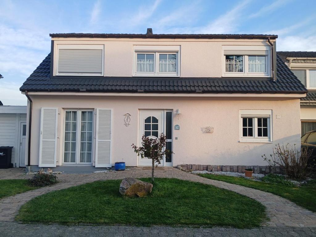 a house with a tree in the front yard at Ferienzimmer Bella Casa in Biebesheim