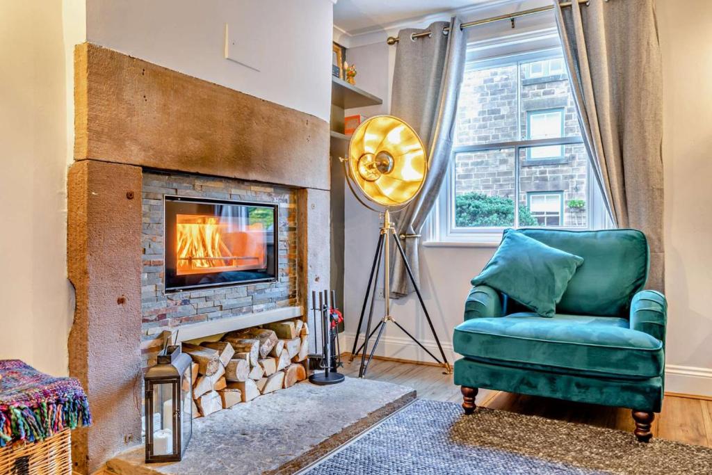 a living room with a fireplace and a green chair at 3 Bed in Belper oc-o28261 in Belper