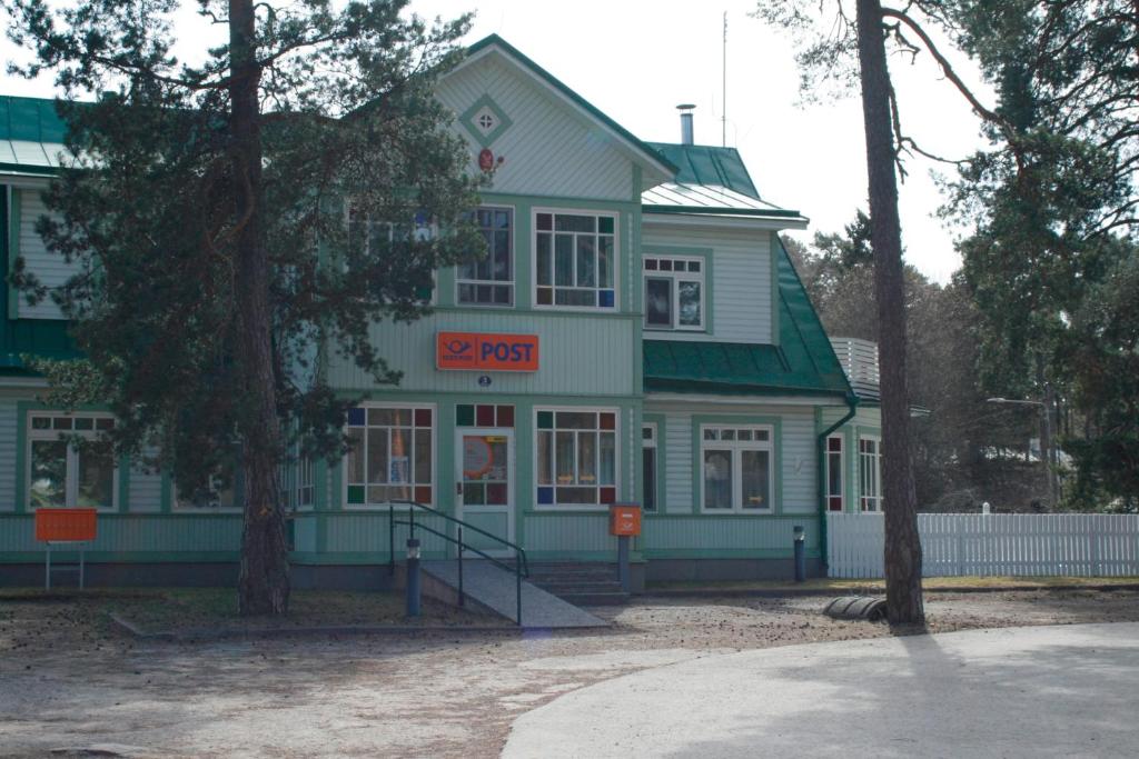 ein grünes Gebäude mit einem Schild davor in der Unterkunft Posti Villa in Võsu