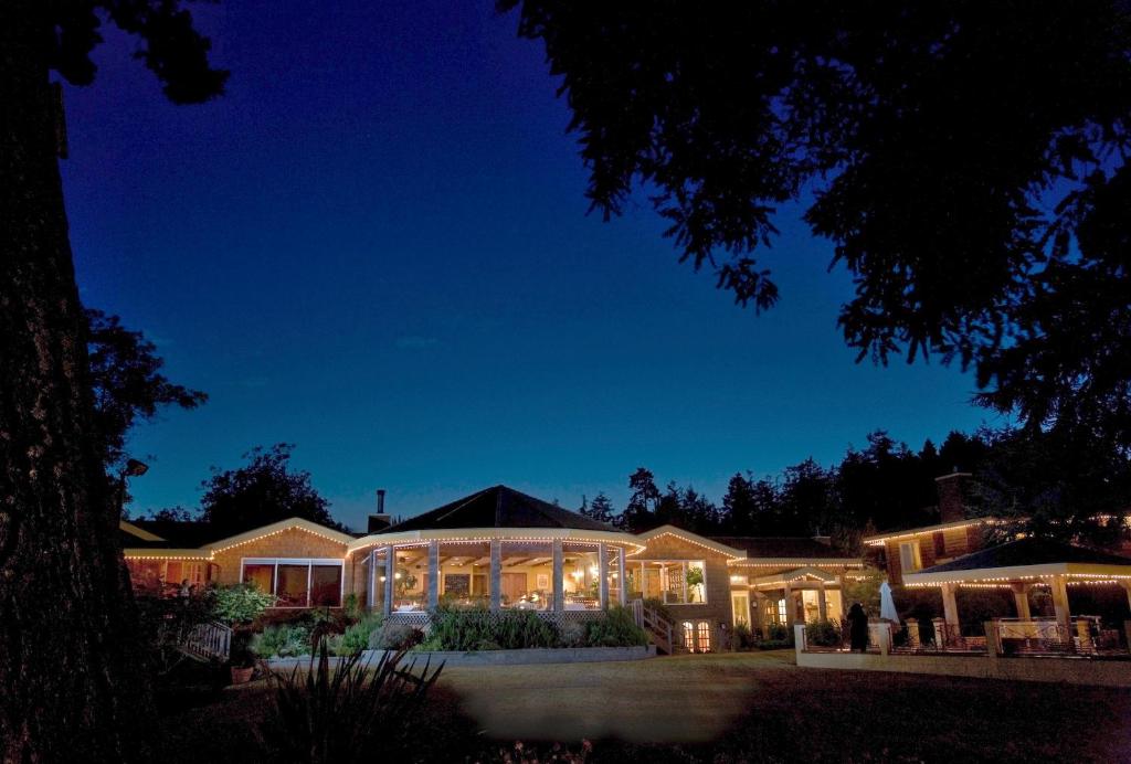 uma grande casa iluminada à noite em Galiano Oceanfront Inn & Spa em Galiano