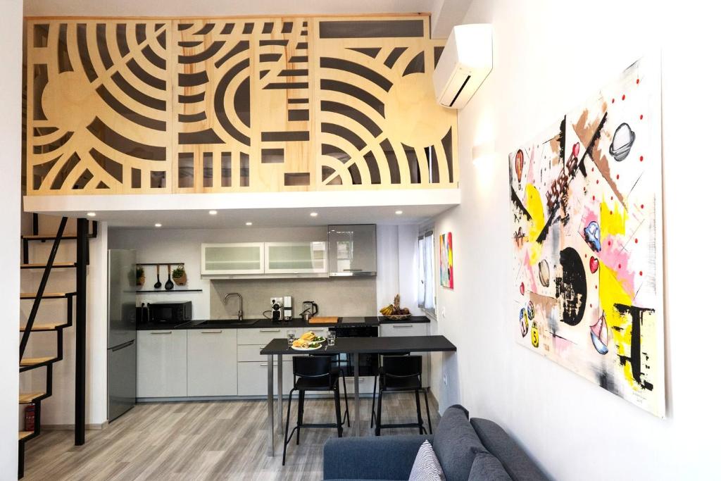 a kitchen and living room with a table and chairs at Central Suites Aegina 1 in Egina