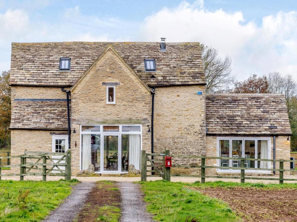 an old stone house with a wooden fence at 2 Bed in Lechlade oc-77493 in Langford